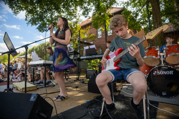Sommerfest 2022: E-Gitarren-Spieler und Sängerin (beide jugendlich) auf einer Freilichbühne